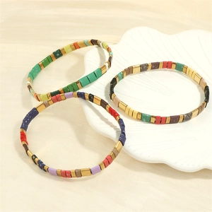 Detailed shot of Bohemian Tila bead stretch bracelets with colorful tiles and gold accents