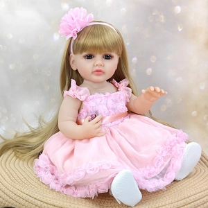 Close-up of 55cm realistic reborn baby doll with blonde hair in a pink floral dress