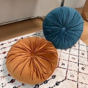 Velvet pumpkin throw pillows in teal and orange with pleated design and center button