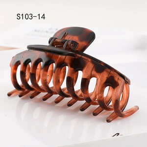 Macro detail of tortoiseshell hair claw clip showing hollow keel design and metal spring