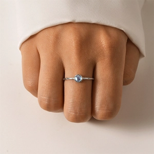 Detailed close-up of a minimalist S925 silver ring with a round blue zircon bezel setting
