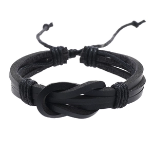 Close-up of black braided leather bracelet featuring a central knot and adjustable cord