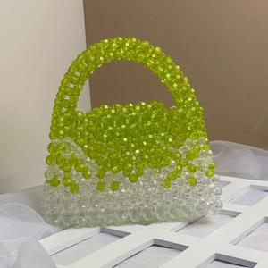 Close-up of handmade beaded handbag showing green and clear gradient beadwork texture