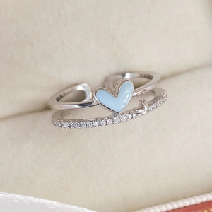 Close-up of double-layered silver heart ring with blue enamel and zircon stones