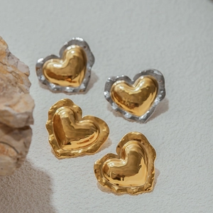 Macro shot of large liquid metal heart earrings in gold and two-tone silver finish
