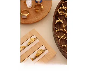 Close-up of vintage gold shell inlay and textured signet rings on a wooden display stand