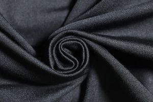 Detail of black synthetic fabric featuring elegant ruched texture and subtle glossy finish