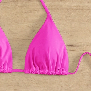 Rose pink triangle halter bikini top with ruched details on a wooden background