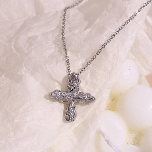 Macro view of silver cross pendant with unique molten lava texture on O-chain necklace