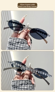 Detail of silver oval metal sunglasses with heart-shaped crystal embellishments