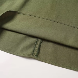 Detailed close-up of olive green linen fabric texture and hem stitching on wide-leg pants