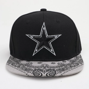 Detail of embroidered star and paisley pattern on a black flat brim snapback cap