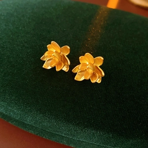Macro-opname van gouden lotus oorknopjes met gelaagde bloemblaadjes en een metalen glans