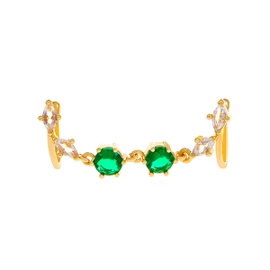 Detail of gold U-shaped nose clip featuring green zircons and clear marquise stones