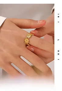 Detail of floral sunflower open ring in gold finish on finger with intricate hollow design