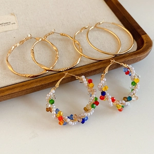 Detailed close-up of vintage hoop earring set with hammered gold and beaded designs