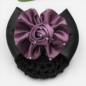 Detail of professional hairnet with purple silk rose and rhinestone accents on black ribbon