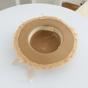 Detail view of straw sun hat featuring interior adjustable drawstring and frayed brim