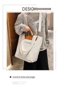 Detail showing white canvas tote with brown leather handles and adjustable shoulder strap