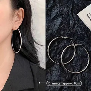 Detailed view of silver hoop earrings showing a 6cm diameter size and polished finish
