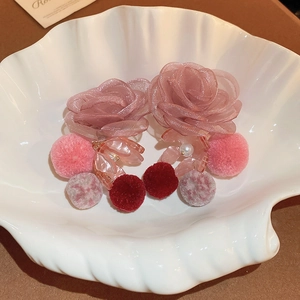 Detailed shot of pink lace flower earrings with soft pom poms and pearl accents