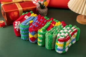 Close-up of 6 pairs of fluffy coral fleece Christmas socks neatly arranged in a cozy gift setting