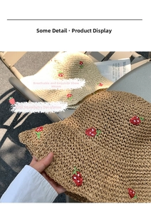 Close-up of hand-woven straw hat showing breathable texture and red strawberry embroidery