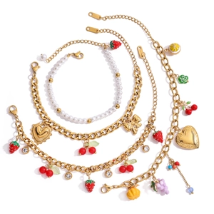 Detail of 18K gold stainless steel jewelry with fruit pendants and white pearls