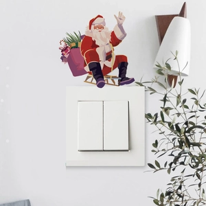 Detailed view of a watercolor Santa on a sled decal applied over a white light switch