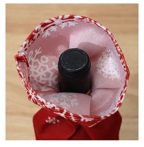 Detailed close-up of Christmas wine bottle cover featuring white snowflake patterns