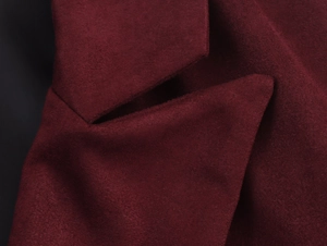 Detailed macro view of the lapel on a burgundy suede coat with premium soft texture