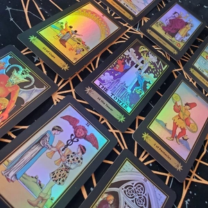 Detail of holographic tarot cards with iridescent finish on star-patterned fabric background