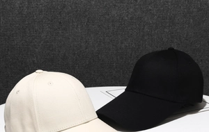 Detailed view of classic cotton baseball caps in black and beige on display stands