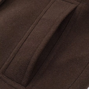 Detailed close-up of the pocket stitching and wool texture on a brown French style short coat