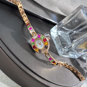 Detailed view of rose gold quartz watch with colorful square zircon stones on display