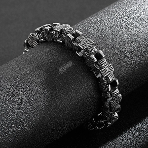 Detail view of hip hop stainless steel cross bracelet with rugged industrial textures