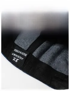 Detail shot of the inner black sweatband and woven logo label on denim baseball cap