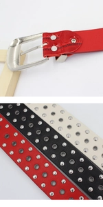 Detail of silver buckles and metal rivets on women's faux leather belts in three colors