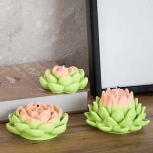 Detail of gradient pink and green succulent candles in various bloom stages on a wood table
