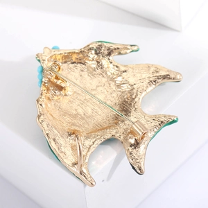 Detail view of the fish brooch back with a secure gold pin clasp and blue bead trim