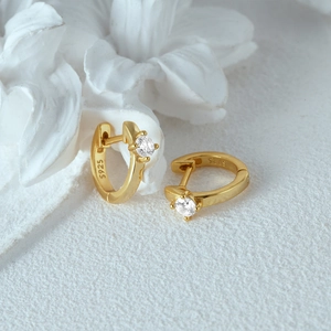 Detail of S925 sterling silver gold-plated huggie earring with round zircon stone