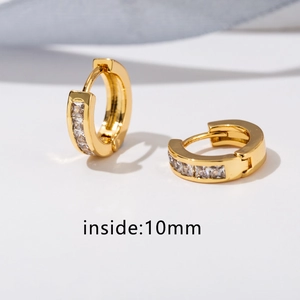 Dettaglio macro di orecchini huggie dorati con zirconi a taglio quadrato e diametro interno 10 mm