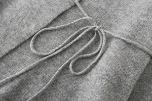 Macro della trama a maglia grigia e dettaglio della cintura sul cappotto in stile francese