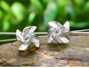 Macro view of S925 sterling silver windmill earrings with matte finish on stone