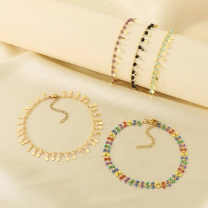 Golden titanium steel anklet with colorful drip glaze pendants on champagne silk background