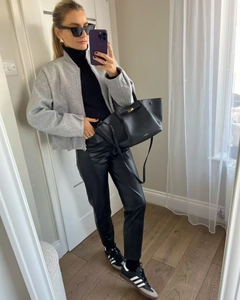Gray baseball collar jacket paired with black leather pants and sneakers for street style