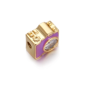 Dettaglio di un ciondolo a forma di fotocamera dorata con smalto viola e pietra in zircone