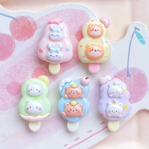 Flat lay of five cute resin animal popsicle charms in pastel colors for DIY crafts