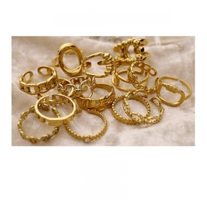 Detail of 18K gold plated stackable rings set with chain and geometric patterns on silk