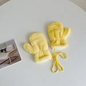 Detailed view of yellow plush baby mittens with a matching neck string for winter warmth